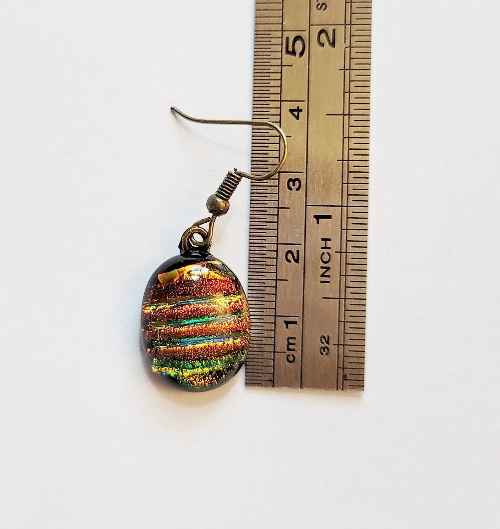 Dichroic rainbow stripes fused glass pierced dangling earrings on antiqued brass tone french wires. Approx 1.5 inches total length